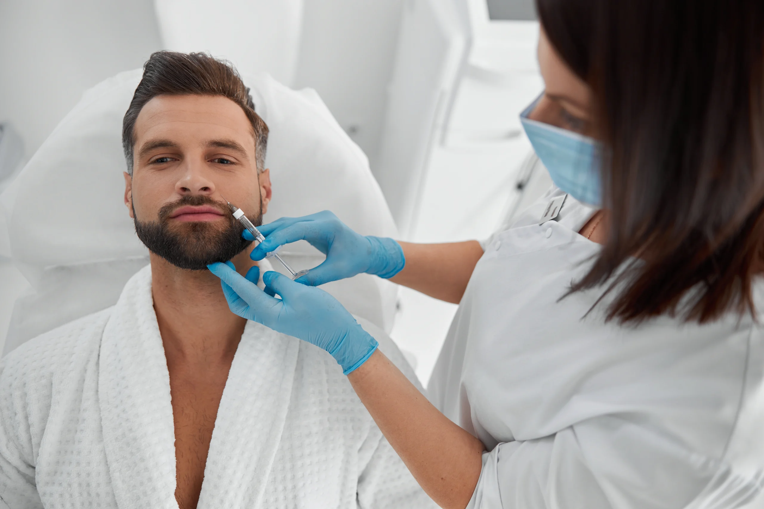 Man receiving a cosmetic procedure in a clinic environment